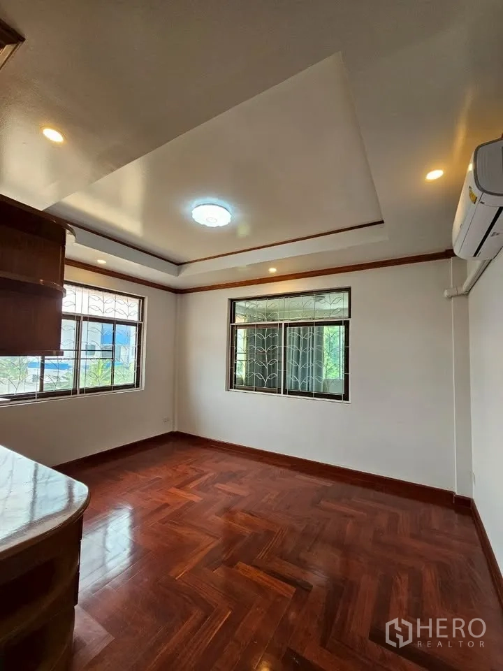 Home Office for rent in Wang Thonglang, Bangkok - Bright room with hardwood floors, AC and corner windows ideal for office setup.