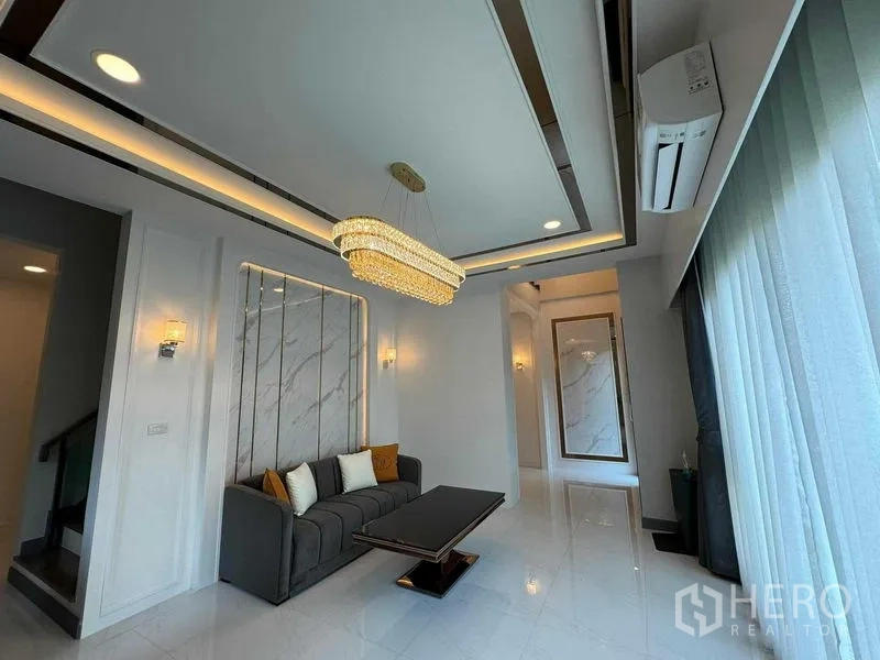 独立式住宅 出租或出售在Bang Na, Bangkok - 会客厅另一角度，水晶吊灯、沙发与落地窗。