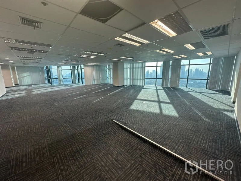 办公空间 出租在Watthana, Bangkok - 开阔办公空间，吊顶灯具与高窗外城市天际线。