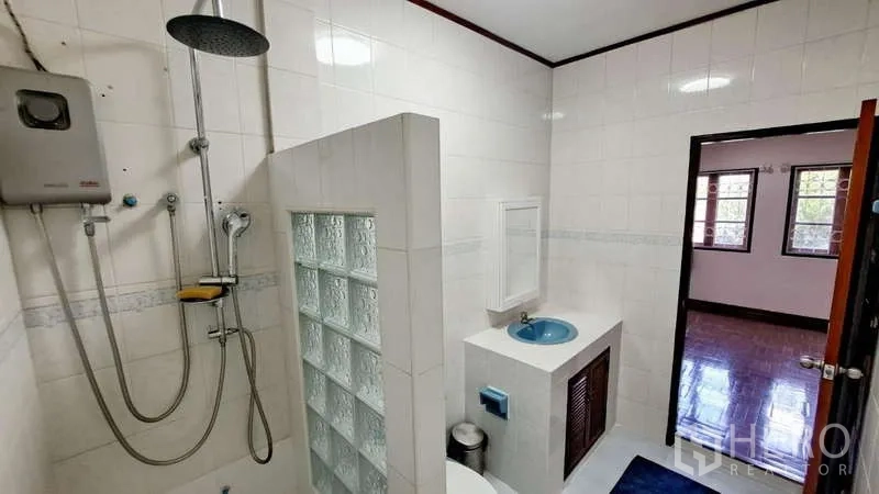 联排别墅 出租在Watthana, Bangkok - 白色瓷砖浴室，顶喷花洒、玻璃砖隔断与洗手台