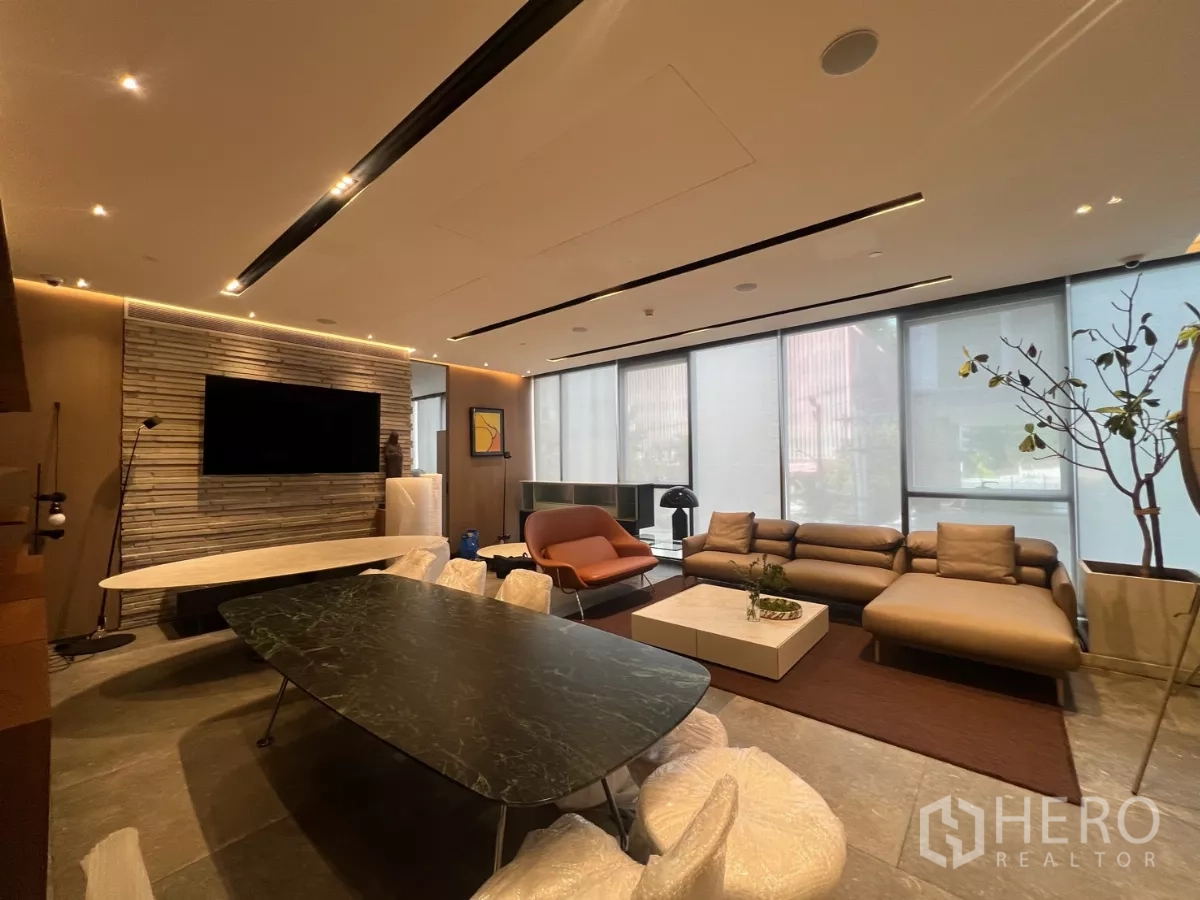 Retail Space for rent - Lounge-style corner with sectional sofa, coffee table, large windows and ambient ceiling lights.