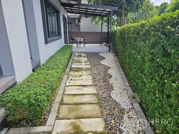 Detached House for rent or sale in Lam Luk Ka, Pathum Thani - Side garden with stepping-stone path, pebble landscaping and a covered patio