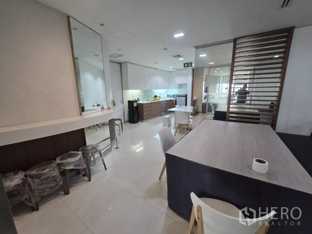 Office Space for rent in Watthana, Bangkok - Pantry and break area with built-in kitchenette, tables and bright lighting.