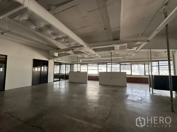 Office Space for rent in Watthana, Bangkok - Bright open office with full-length windows, air-conditioning ducts, and polished concrete ready for fit-out.