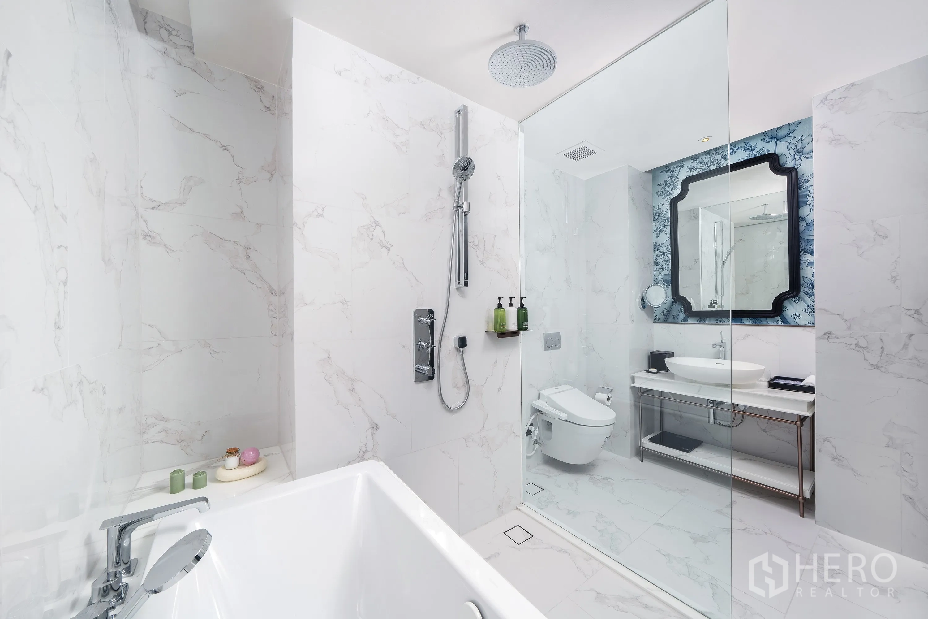 Condominium for rent in Khlong Toei, Bangkok - Marble bathroom with bathtub, glass shower, rain showerhead, vanity, and toilet.