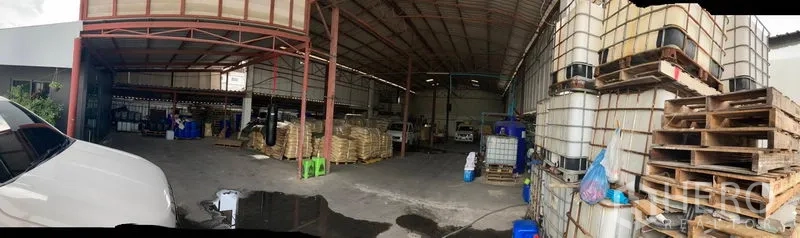 Warehouse for sale in Lam Luk Ka, Pathum Thani - Wide-span warehouse interior with high steel roof, pallets and IBC tanks, concrete floor and covered loading area in Lam Luk Ka.