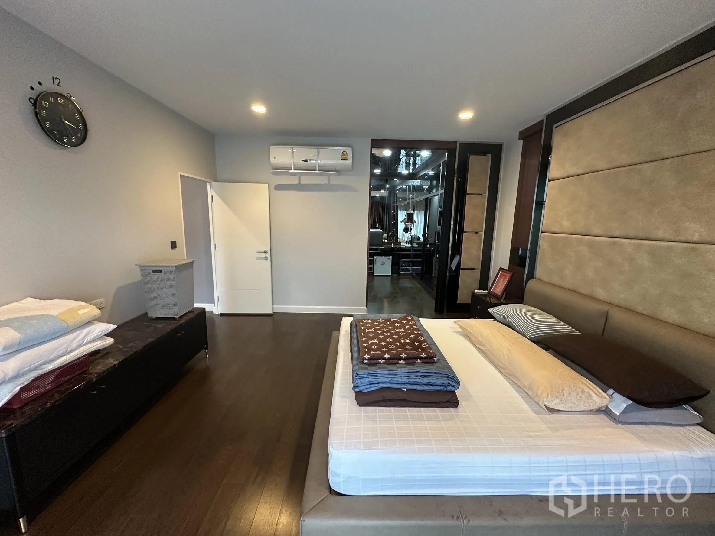 Detached House for rent in Lam Luk Ka, Pathum Thani - Master bedroom with upholstered headboard and walk-in closet corridor.