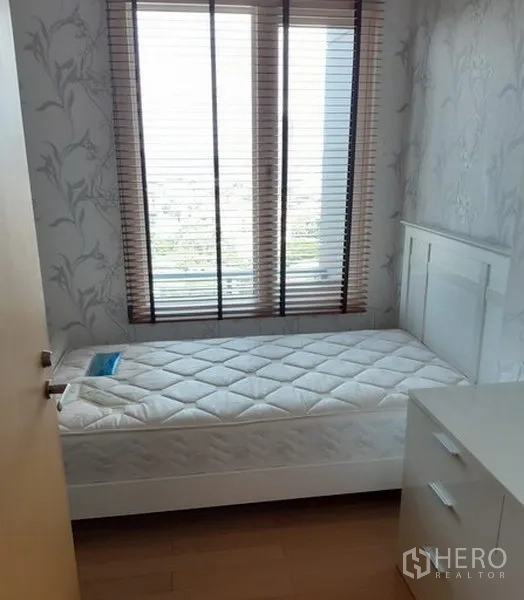 Condominium for rent in Khlong Toei, Bangkok - Cozy secondary bedroom with single bed, dresser, and large window with blinds.
