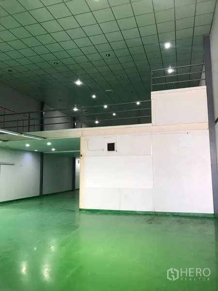 Factory for rent in Bang Phli, Samut Prakan - Spacious hall featuring a mezzanine platform and grid ceiling lights.