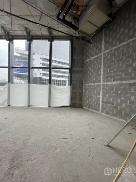 Retail Space for rent - High‑ceiling retail interior with visible ducting and full‑height windows providing strong street visibility.