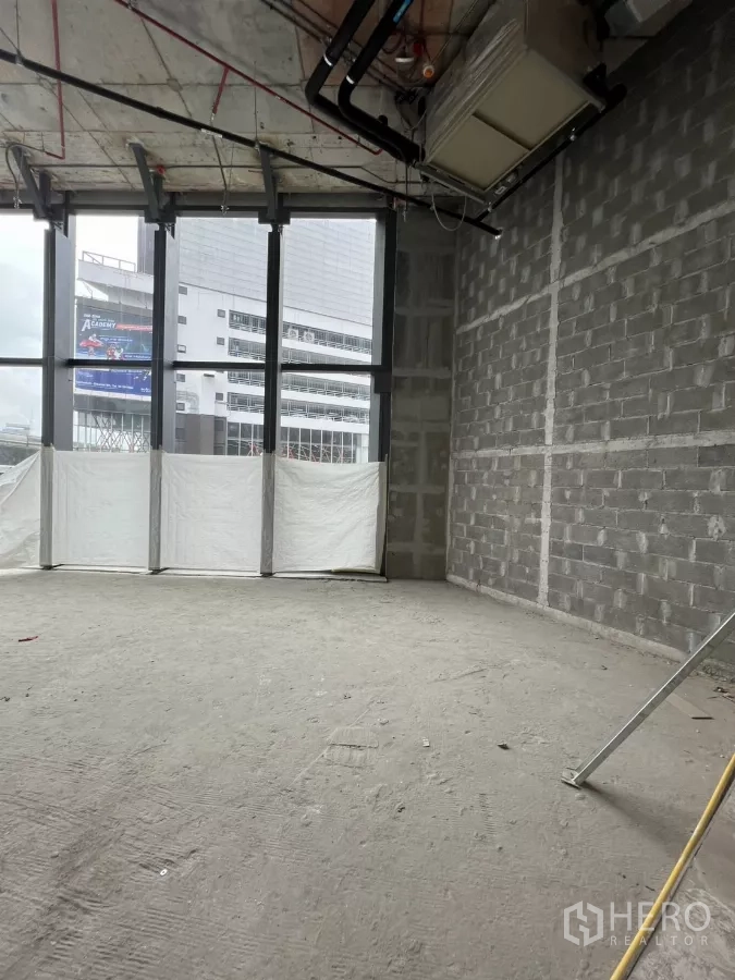Retail Space for rent - High‑ceiling retail interior with visible ducting and full‑height windows providing strong street visibility.