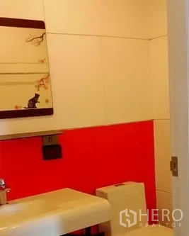 Office Space for rent in Khlong Toei, Bangkok - Powder room with wall mirror, white basin and red accent tiles.