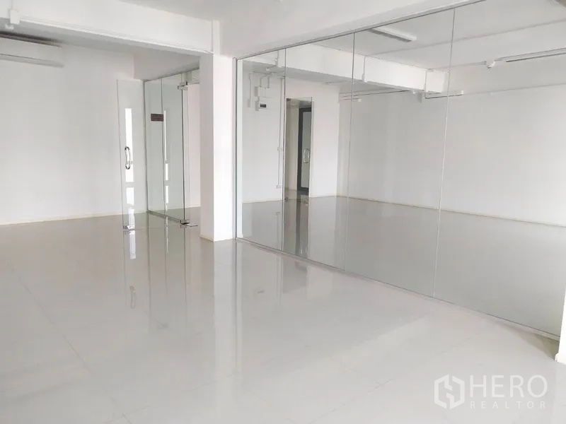 Office Space for rent in Bang Na, Bangkok - Open-plan office area with sliding glass doors and white walls.