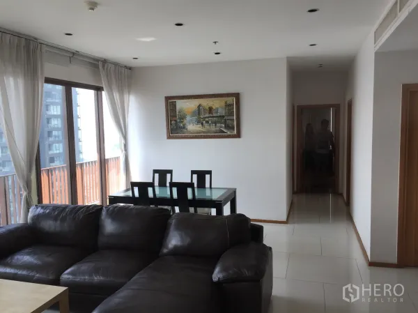 Condominium for rent or sale in Khlong Toei, Bangkok - Bright living and dining area with large windows, sheer curtains, and sliding doors to a balcony.