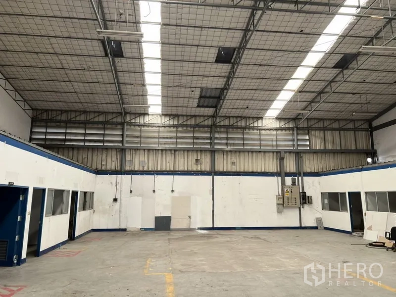 Warehouse for rent in Suan Luang, Bangkok - Spacious warehouse floor under a skylit high ceiling with ventilation panels and power boards.