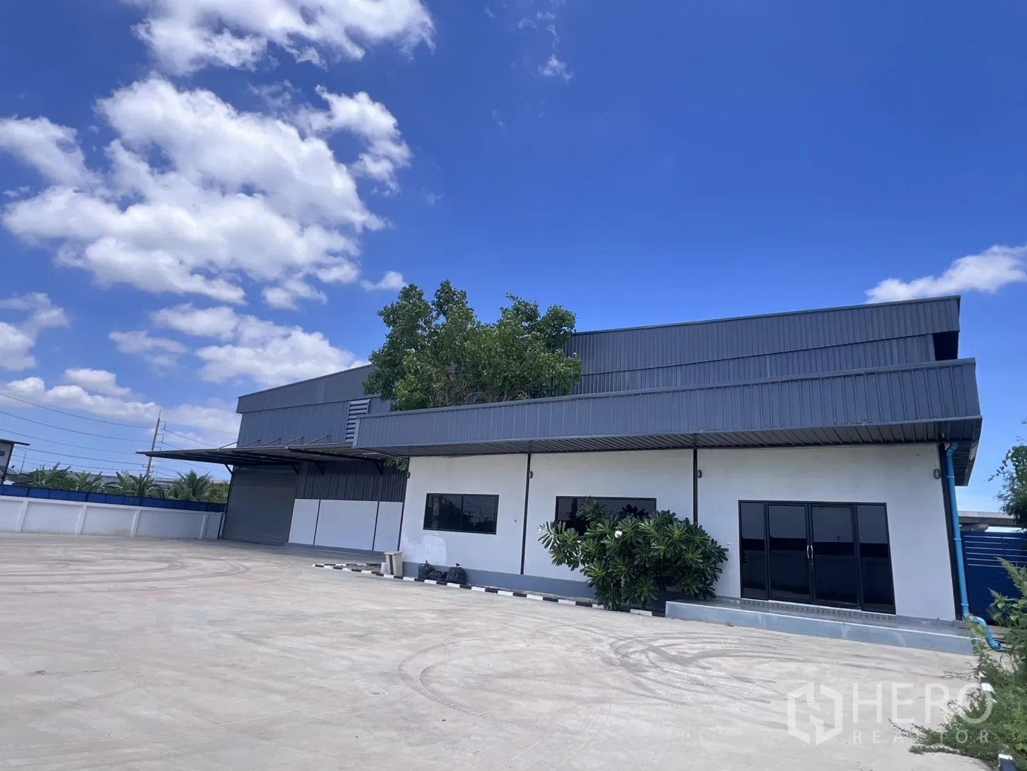 โกดัง for rent in Mueang Samut Sakhon, Samut Sakhon - ด้านนอกโกดังพร้อมอาคารสำนักงานและลานคอนกรีตกว้าง.