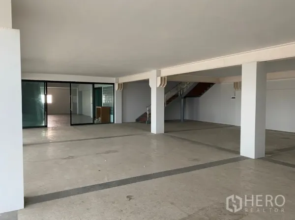 Warehouse for rent in Lat Krabang, Bangkok - Open-plan warehouse interior with glass-partitioned office and internal staircase.