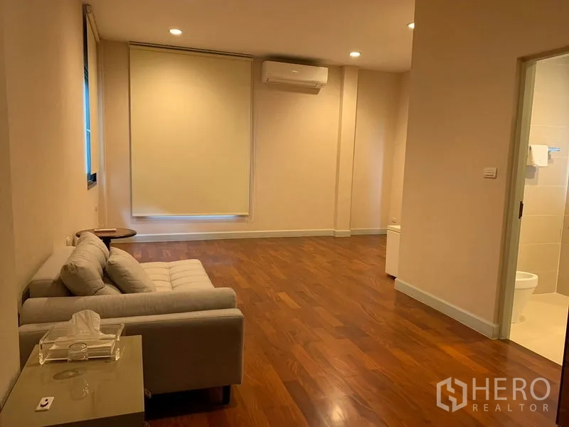 独立式住宅 出租或出售在Khan Na Yao, Bangkok - 宽敞卧室休息区，木地板、沙发、空调与套卫门。