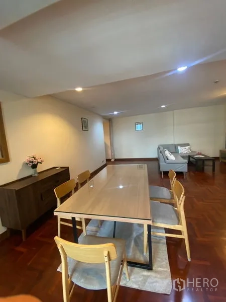 Condominium for rent in Pathum Wan, Bangkok - View from dining area toward the living room, showing a six-seat table on a rug.