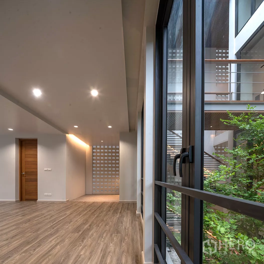 Home Office for rent or sale in Phra Khanong, Bangkok - Upper floor corridor with wood flooring and views to the central atrium.