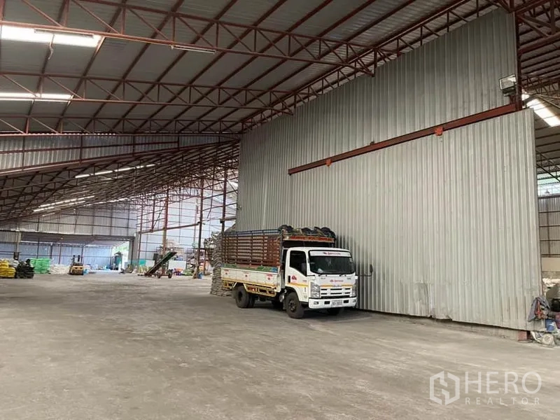 Warehouse for sale in Lam Luk Ka, Pathum Thani - Large opening between warehouse sections revealing a bright, column‑free storage zone.