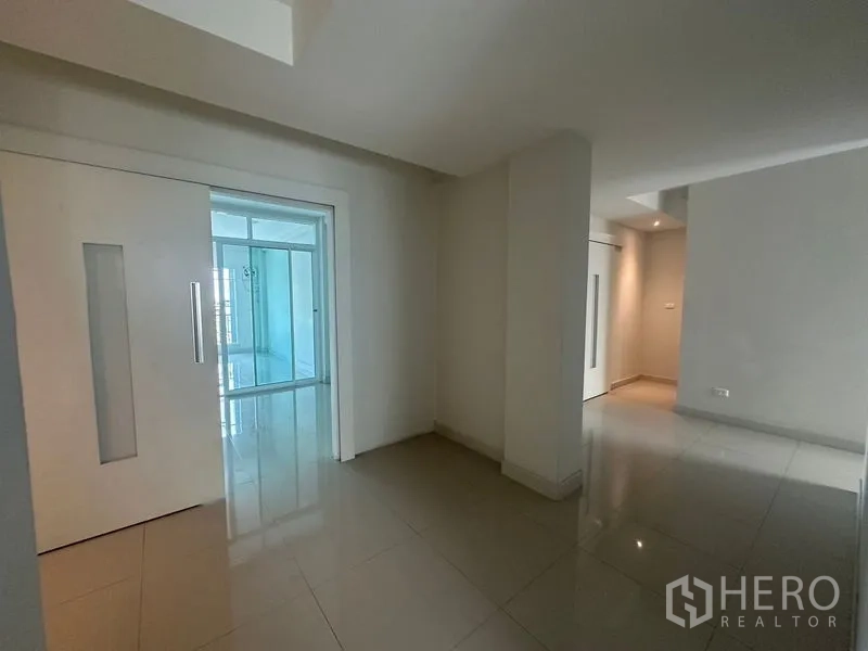 Home Office for rent in Bang Na, Bangkok - Hallway with sliding doors opening to a glass-enclosed room.