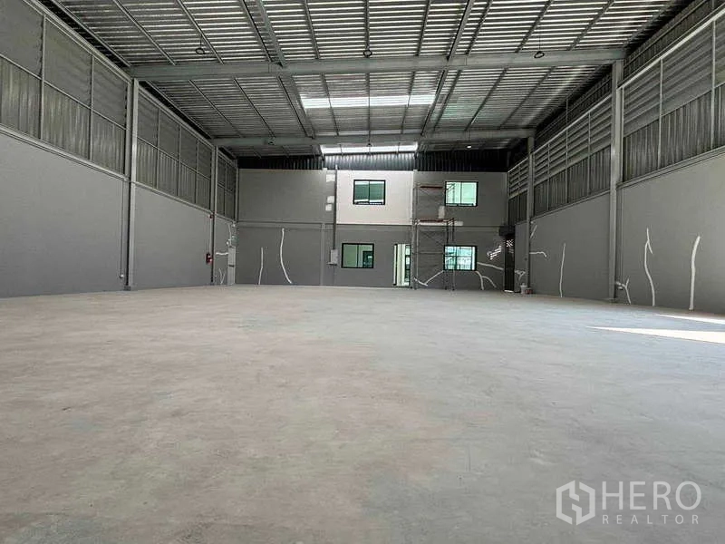 Factory for rent in Bang Bo, Samut Prakan - Clear‑span warehouse floor facing the integrated two‑storey office, lit by skylights.