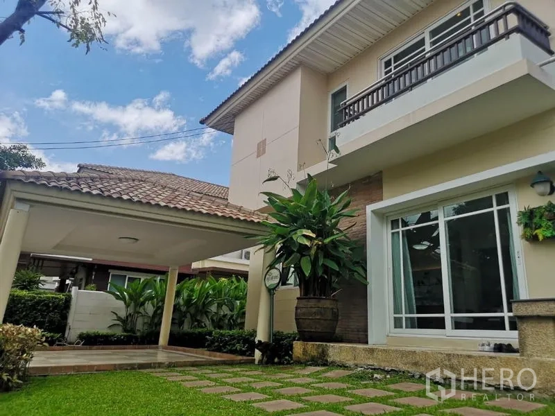 Detached House for rent - Side view of the house with lawn, stepping stones, tropical plants and covered parking.