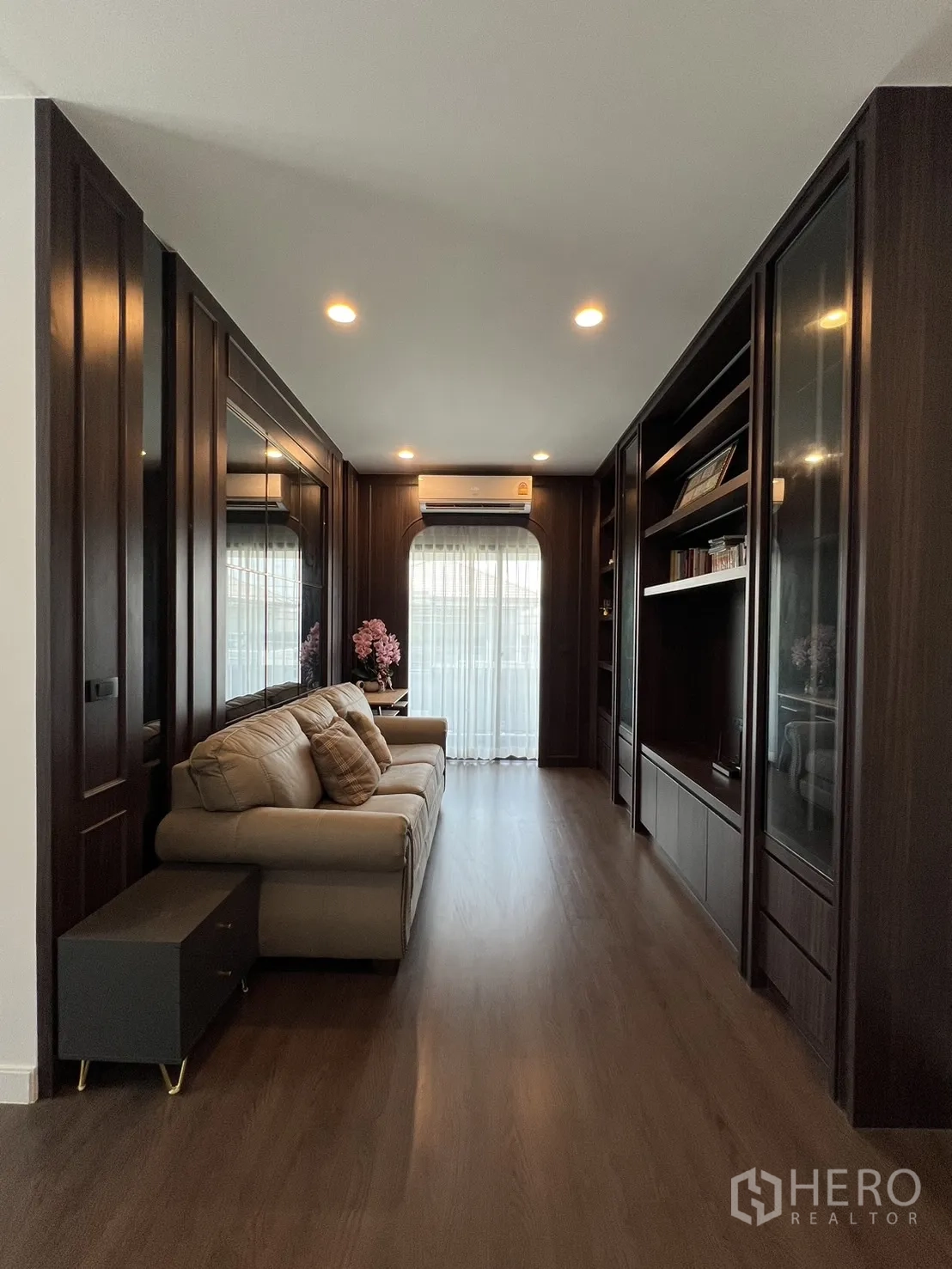 Detached House for rent or sale in Bang Kapi, Bangkok - Upstairs family lounge with built-in shelves and sofa by balcony.