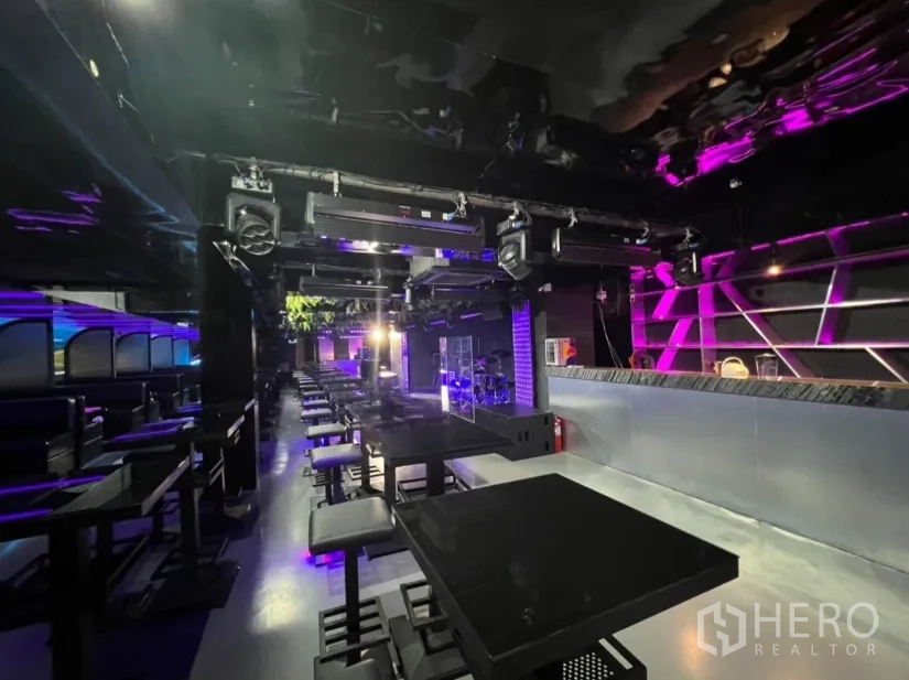 Retail Space for rent in Watthana, Bangkok - Neon-lit retail interior with rows of tables, a stage and overhead lighting rig.