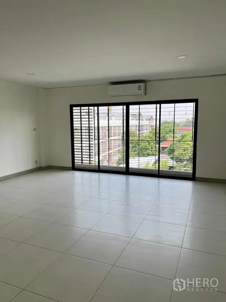 Home Office for rent in Bang Kapi, Bangkok - Spacious upper-floor room with large sliding windows, air conditioning and green neighborhood views.