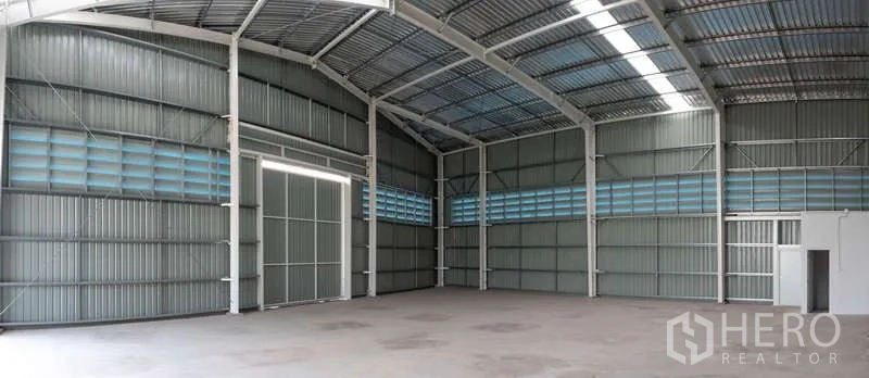 Warehouse for rent in Khlong Luang, Pathum Thani - Panoramic interior of a high-clearance warehouse with skylight strips and ventilation louvres.