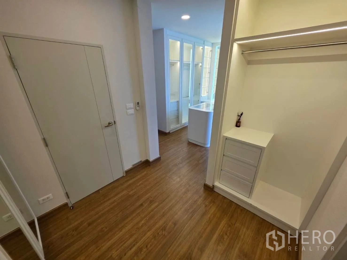 Detached House for rent or sale in Bang Phli, Samut Prakan - Hallway with wood floors leading to built-in closet area.