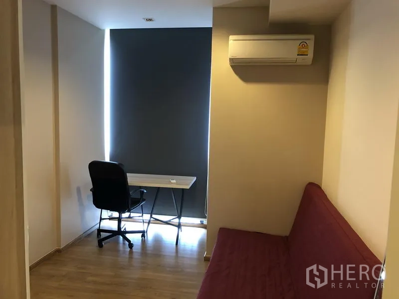 Condominium for rent in Watthana, Bangkok - Second bedroom arranged as a home office with desk, chair and wall-mounted air-conditioner.