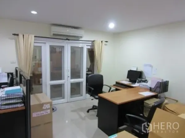 带办公室的家 出租或出售在Wang Thonglang, Bangkok - 明亮的办公房，配有办公桌、电脑和玻璃法式门。