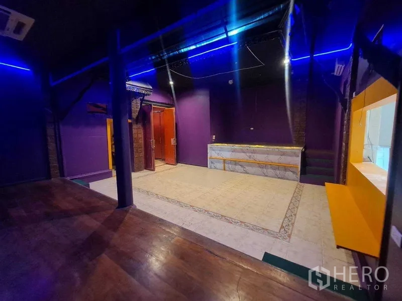 Retail Space for rent in Watthana, Bangkok - View from the raised stage toward the service counter under ceiling ducts and blue strip lights.