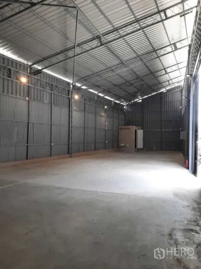 Warehouse for rent in Sathon, Bangkok - Full-length view of high-ceiling warehouse with bright front opening and high-bay lights.