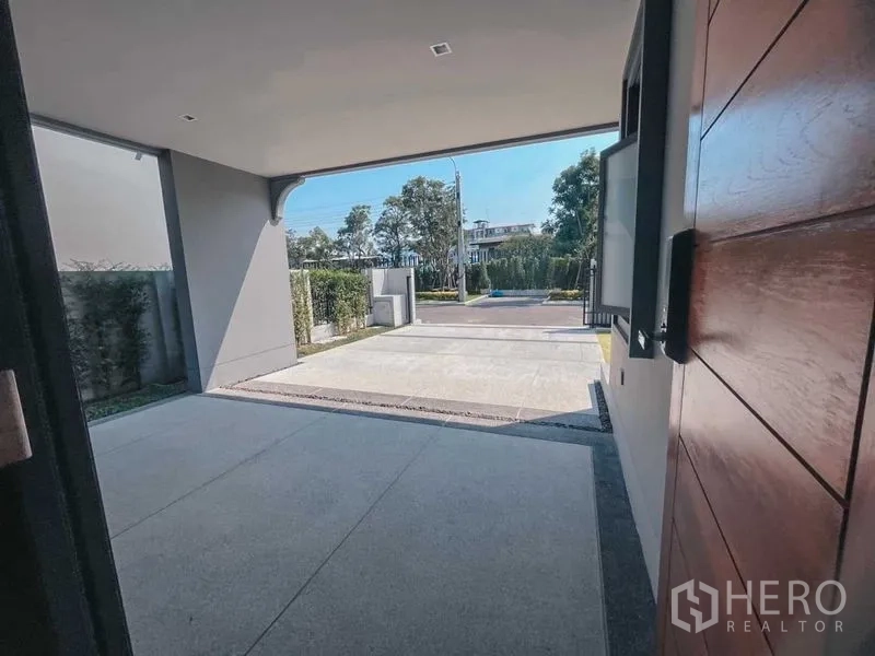 Detached House for sale in Mueang Nonthaburi, Nonthaburi - Covered two-car carport and driveway viewed from the front porch.