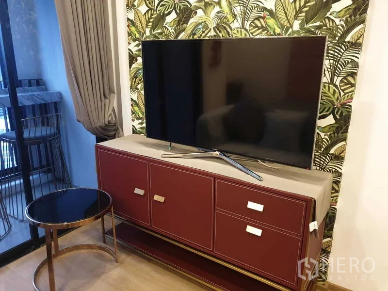 Condominium for rent in Bang Rak, Bangkok - Large flat-screen TV on burgundy console near the balcony.