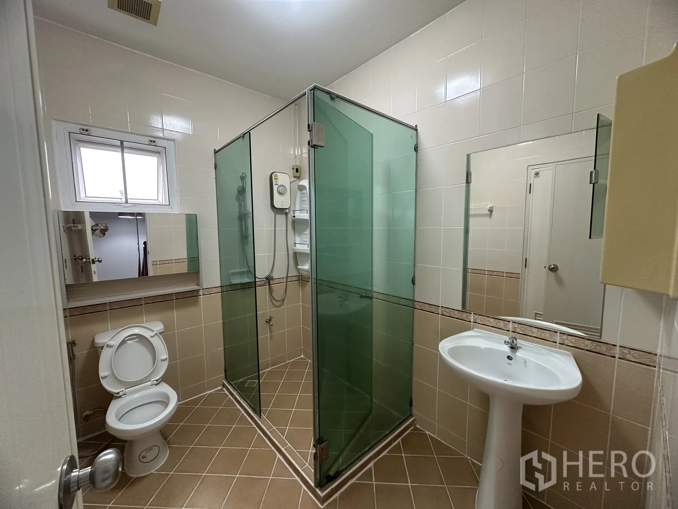 Townhouse for sale in Lam Luk Ka, Pathum Thani - Upper bathroom with green glass shower, basin and window.