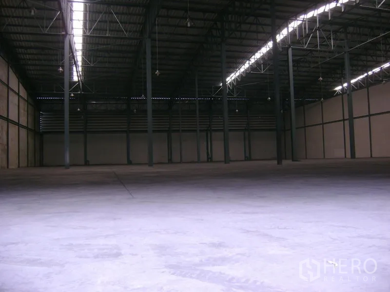 Warehouse for rent in Mueang Samut Sakhon, Samut Sakhon - Wide open warehouse floor area with tall columns, skylight strip and ample headroom.