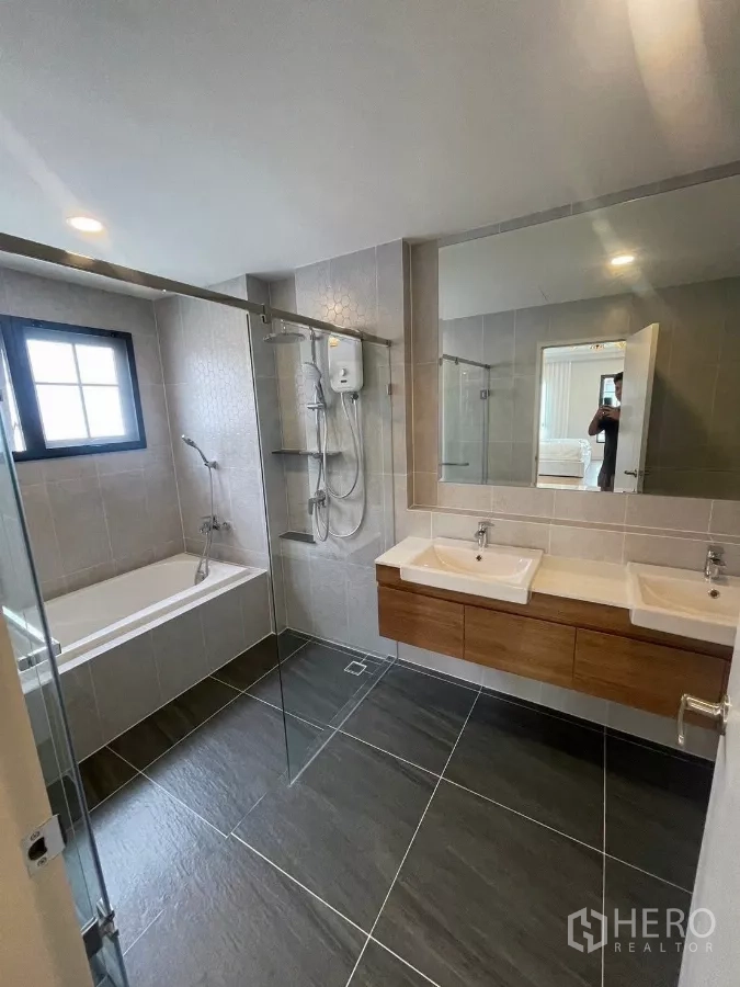 Detached House for rent in Bang Phli, Samut Prakan - Master bathroom with double vanity, glass shower enclosure and bathtub.