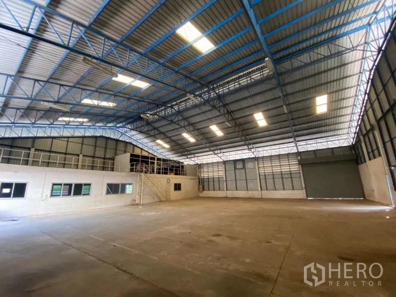 Factory for rent in Lat Lum Kaeo, Pathum Thani - Open factory floor with concrete slab, mezzanine office and wide roller door.