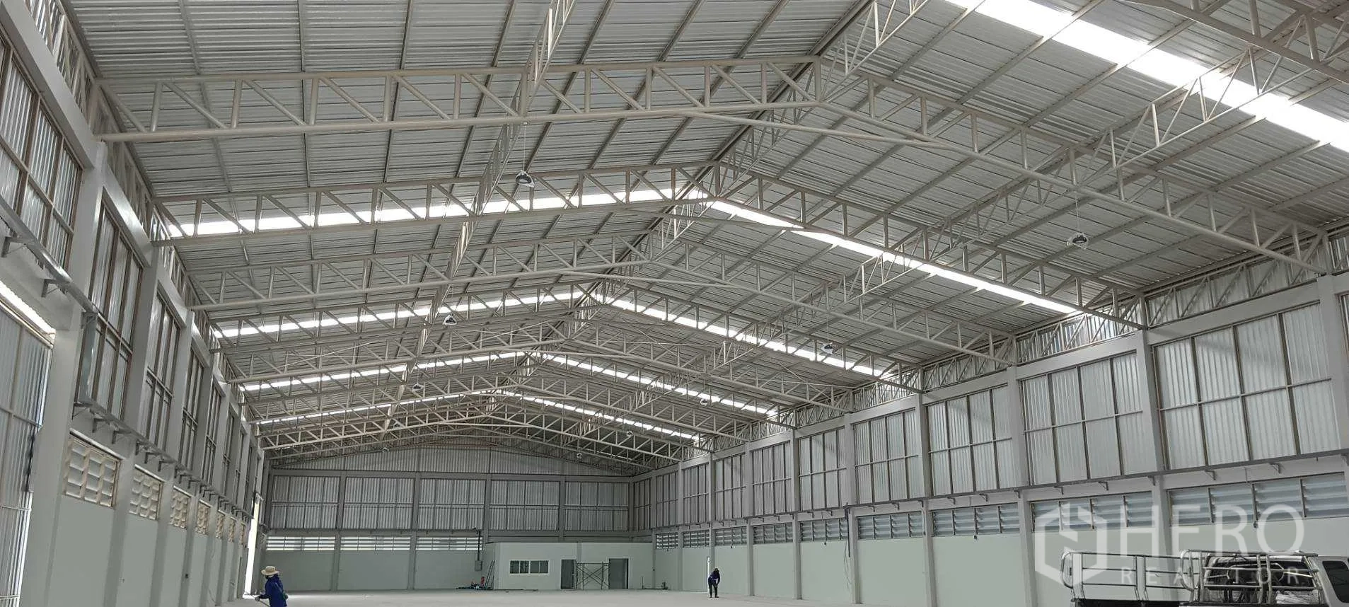 Warehouse for rent or sale in Lam Luk Ka, Pathum Thani - Wide clear-span storage hall with smooth floor and ventilation panels.