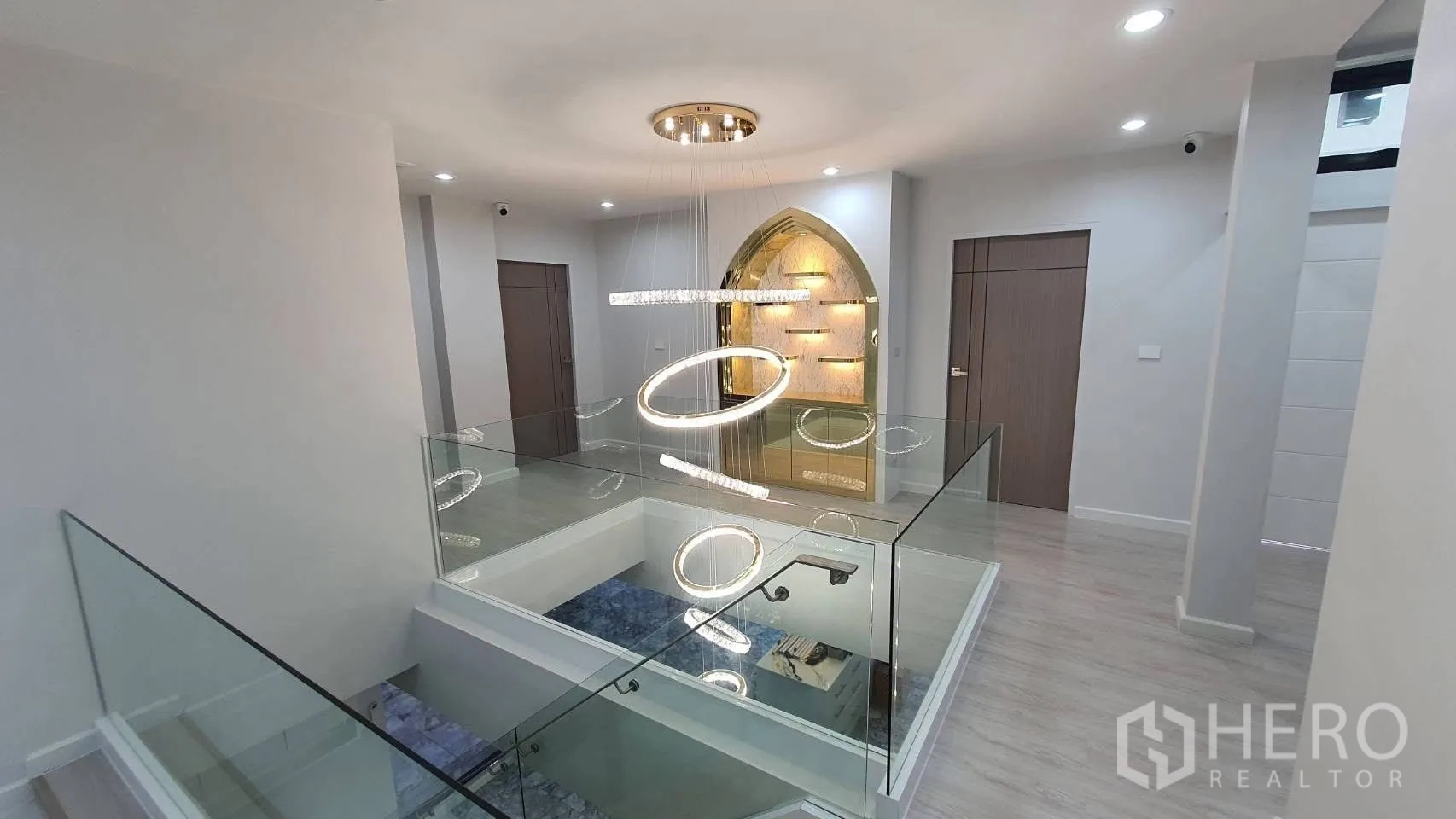 独栋房屋 for rent in Lat Phrao, Bangkok - 二楼走廊，玻璃护栏与环形吊灯。