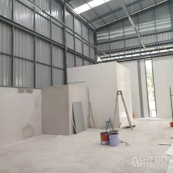 Warehouse for rent in Khlong Toei, Bangkok - Warehouse interior with small office module under construction and ladder.