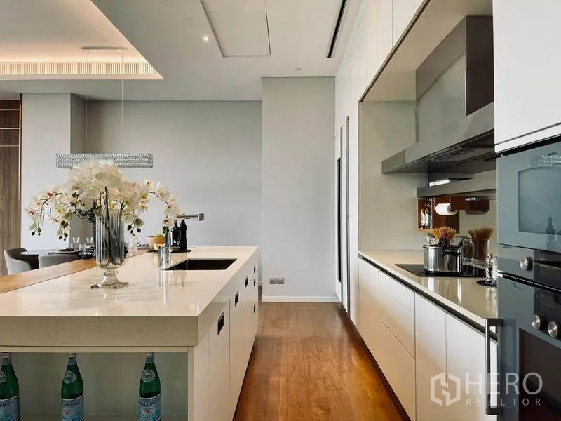 Condominium for sale in Pathum Wan, Bangkok - Open-plan kitchen featuring a large island, built-in appliances and adjacent dining area.