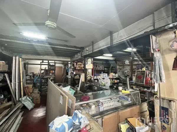 零售空间 出租在Watthana, Bangkok - 店内玻璃展示柜、吊扇及金属货架，陈列五金用品