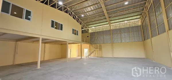 Warehouse for rent in Lat Krabang, Bangkok - Spacious high-clear warehouse interior with steel trusses and a mezzanine office.