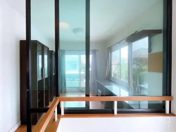 Detached House for rent in Bang Na, Bangkok - Bright upstairs landing with floor-to-ceiling glass partition and windows opening to a balcony.